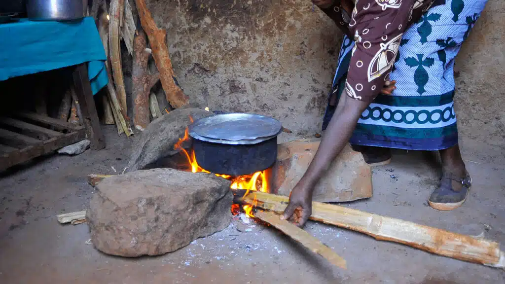 A Nigerian woman cooking with firewood in a rural community in Abuja, Nigeria's state capital